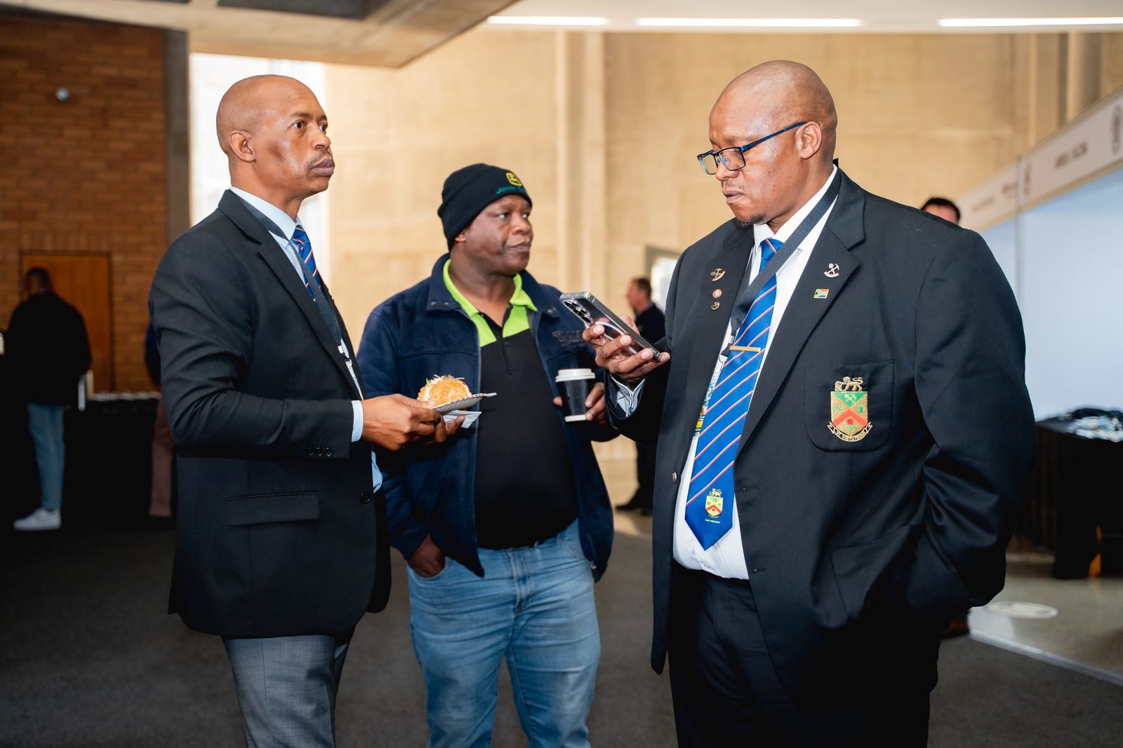 Three delegates in conversation during a break