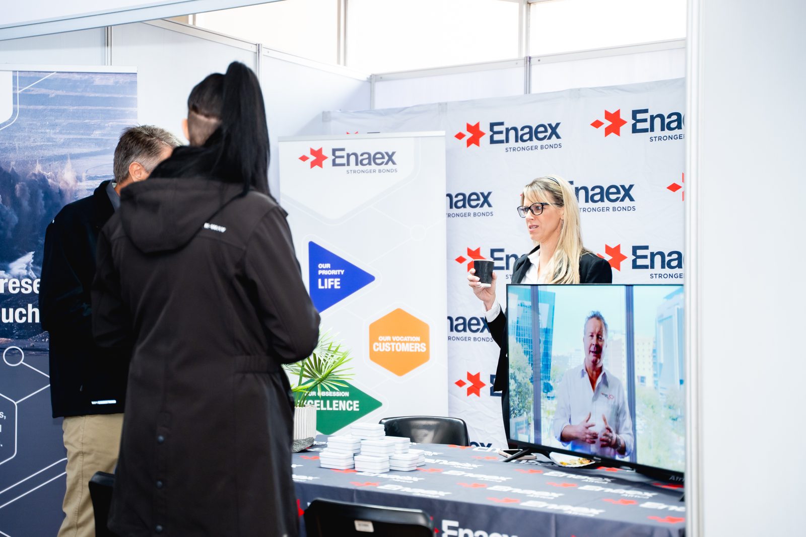 Delegates watching a screen demonstration at an exhibition stand