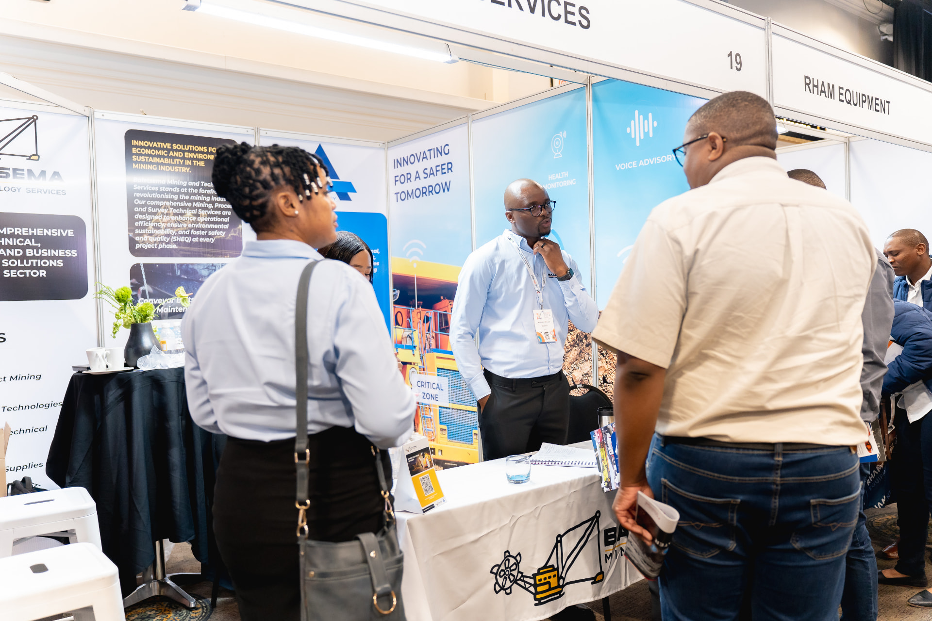 Delegates in conversation at an exhibition stand on the expo floor