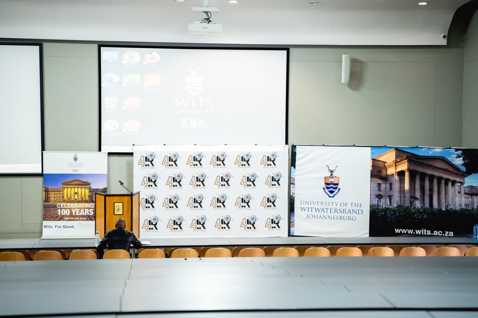 Main auditorium stage with branded backdrop at Wits University
