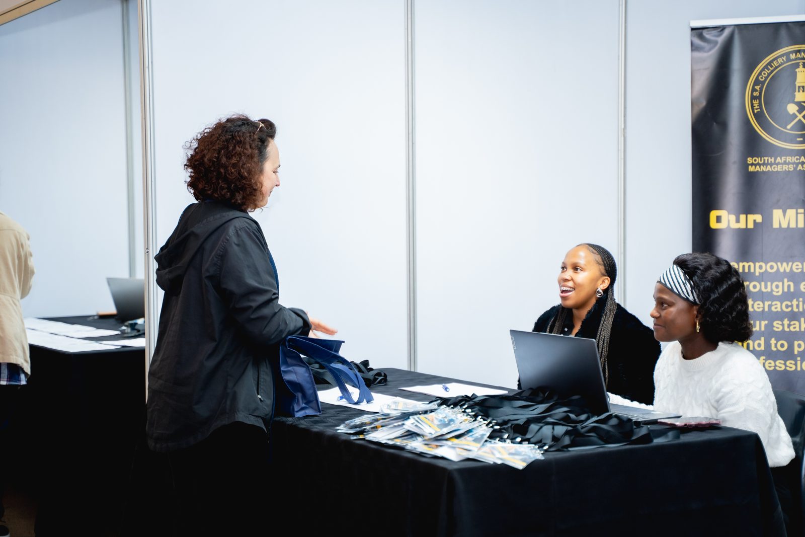 Delegates speaking to exhibitors across a stand table